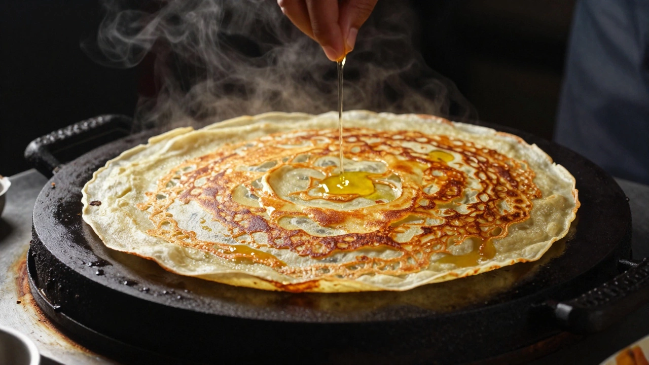 Golden crispy dosa cooking on a hot iron griddle